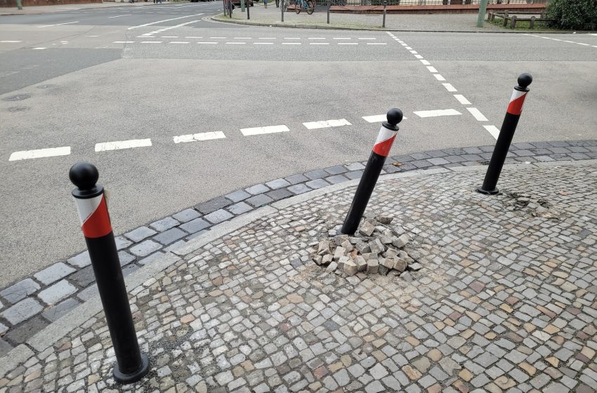 three black and red poles sticking out of the ground